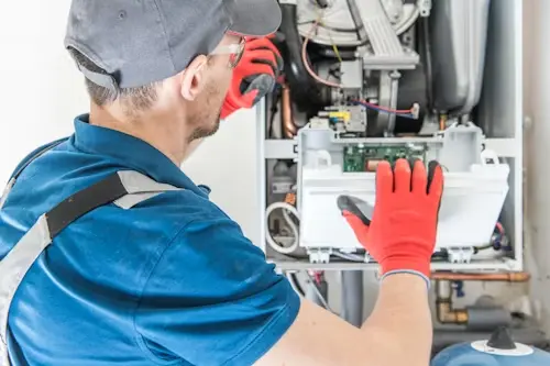 A Gas Safe registered heating engineer repairing a combi boiler system in a Watford home.